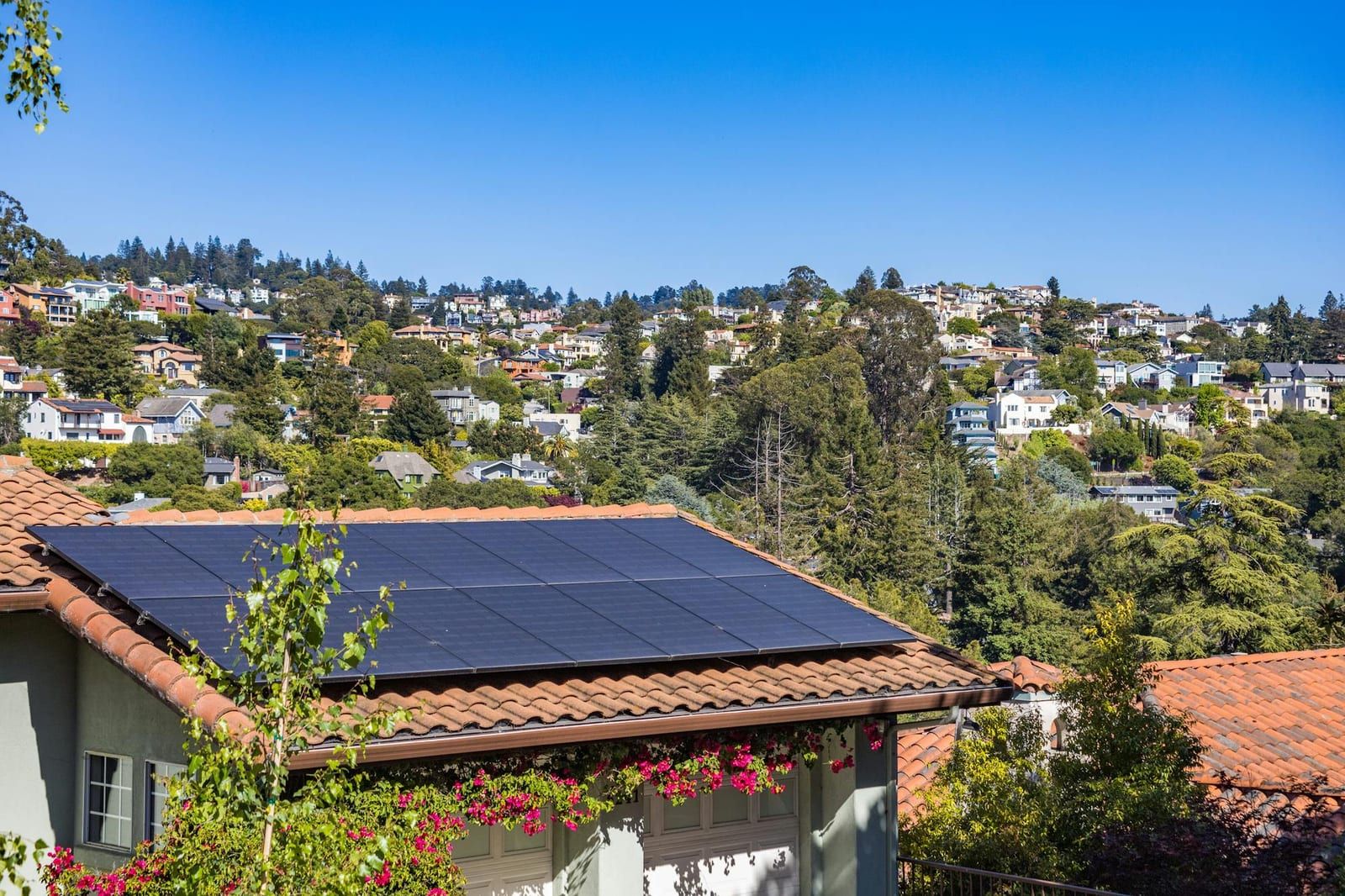 A home with rooftop solar panels under a clear, sunny sky